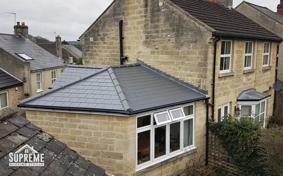 Single-storey extension with a new grey tiled hipped roof and white windows