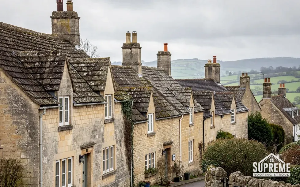 Terrace of stone cottages with dormer windows and weathered stone tile roofs