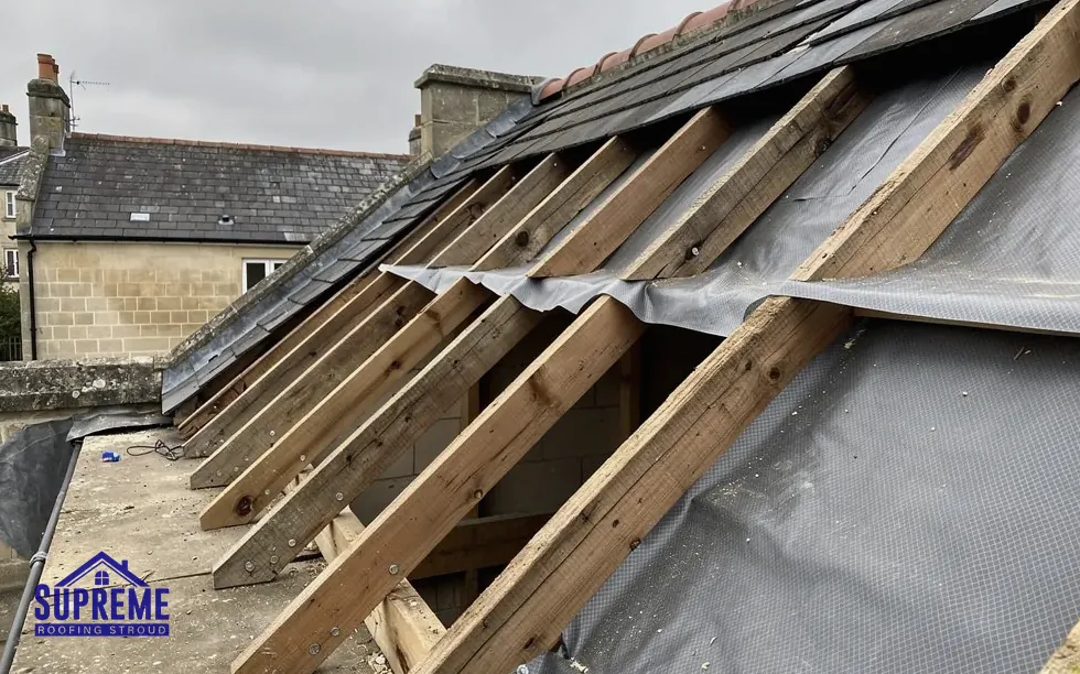 Stripped roof showing exposed rafters, battens and torn underlay membrane