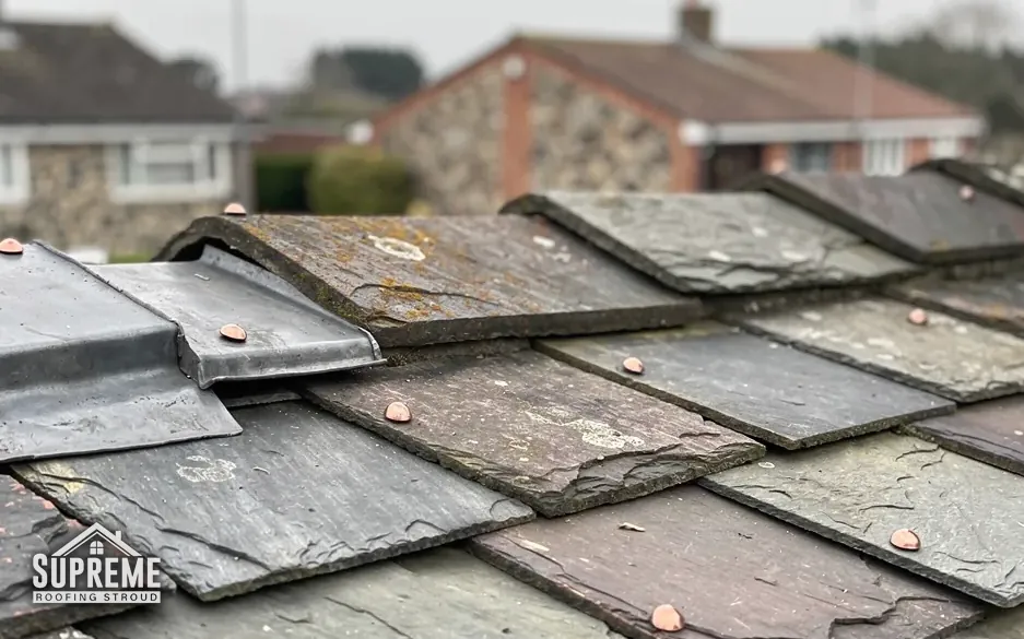 Close view of weathered slates with copper nails on a roof